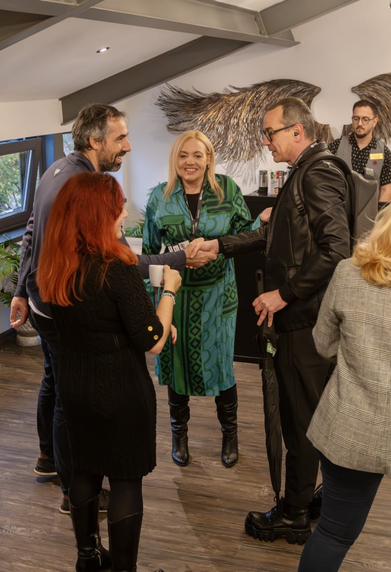 Attendees greeting and shaking hands at the BRINEL IQANTO Cloud Insights AI Innovation Edition event