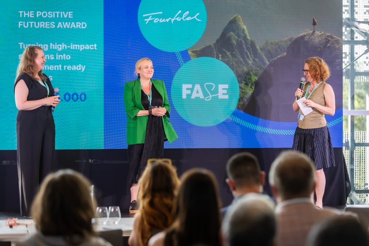 Three women on stage at re:Marc 2026 in Budapest in front of a screen reading The Positive Futures Award with Fourfold and FASE logos